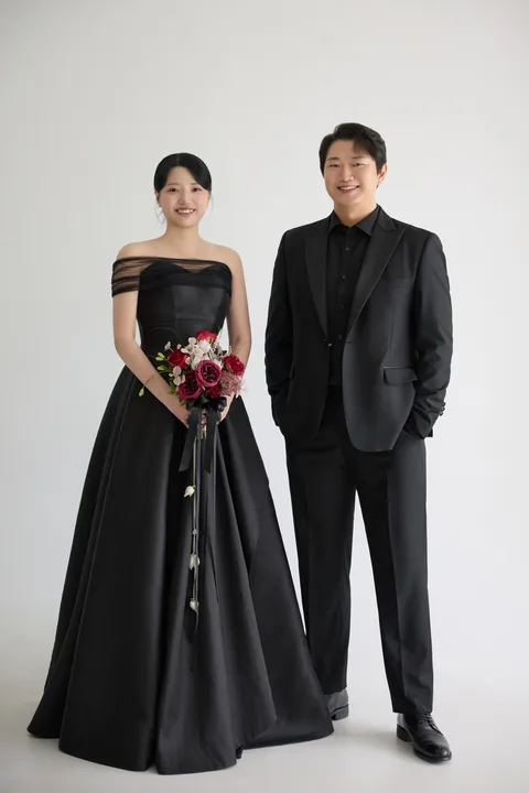 검은 드레스와 정장을 입고 나란히 선 동주와 경하